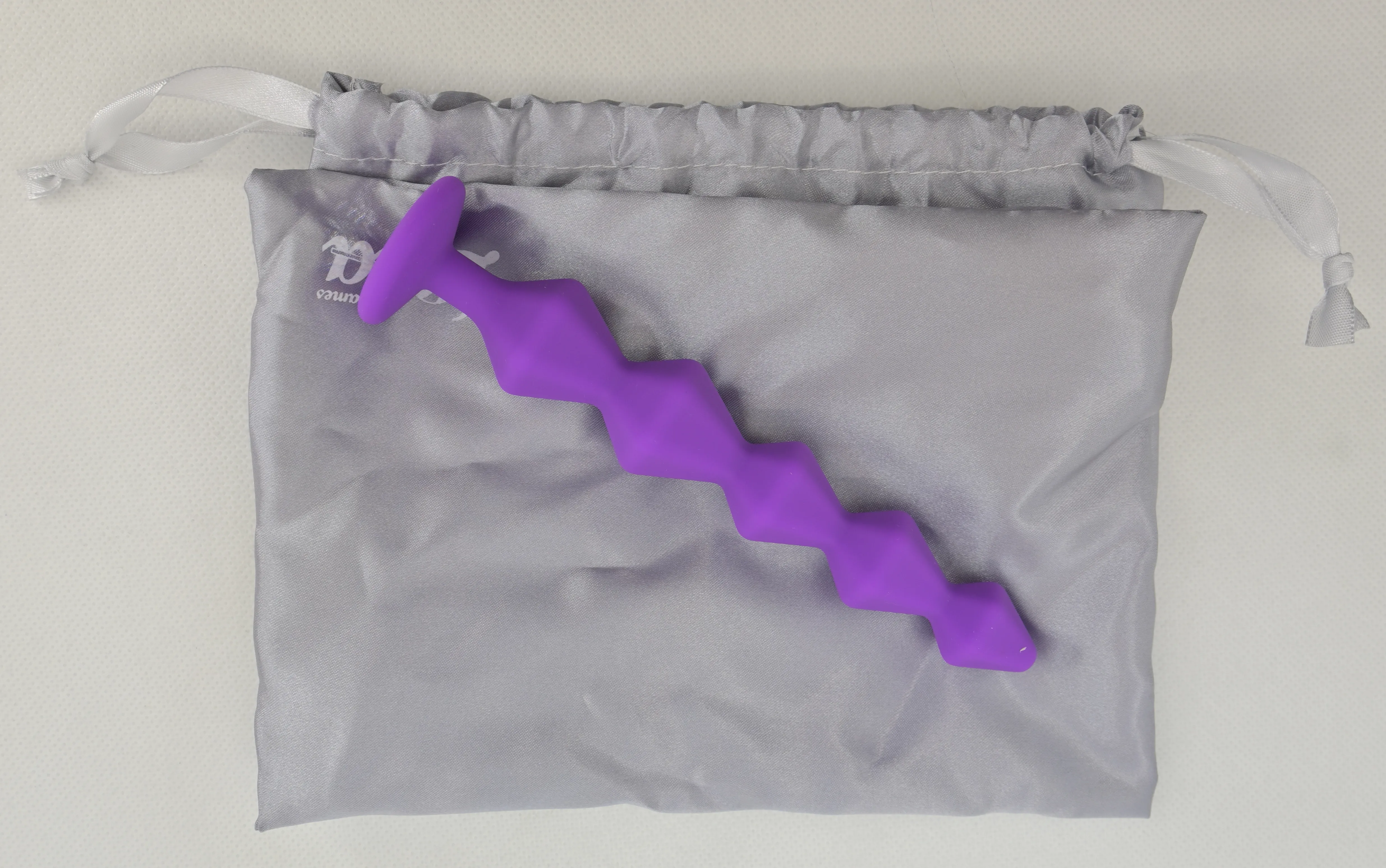 Фиолетовая анальная цепочка на сером мешочке
