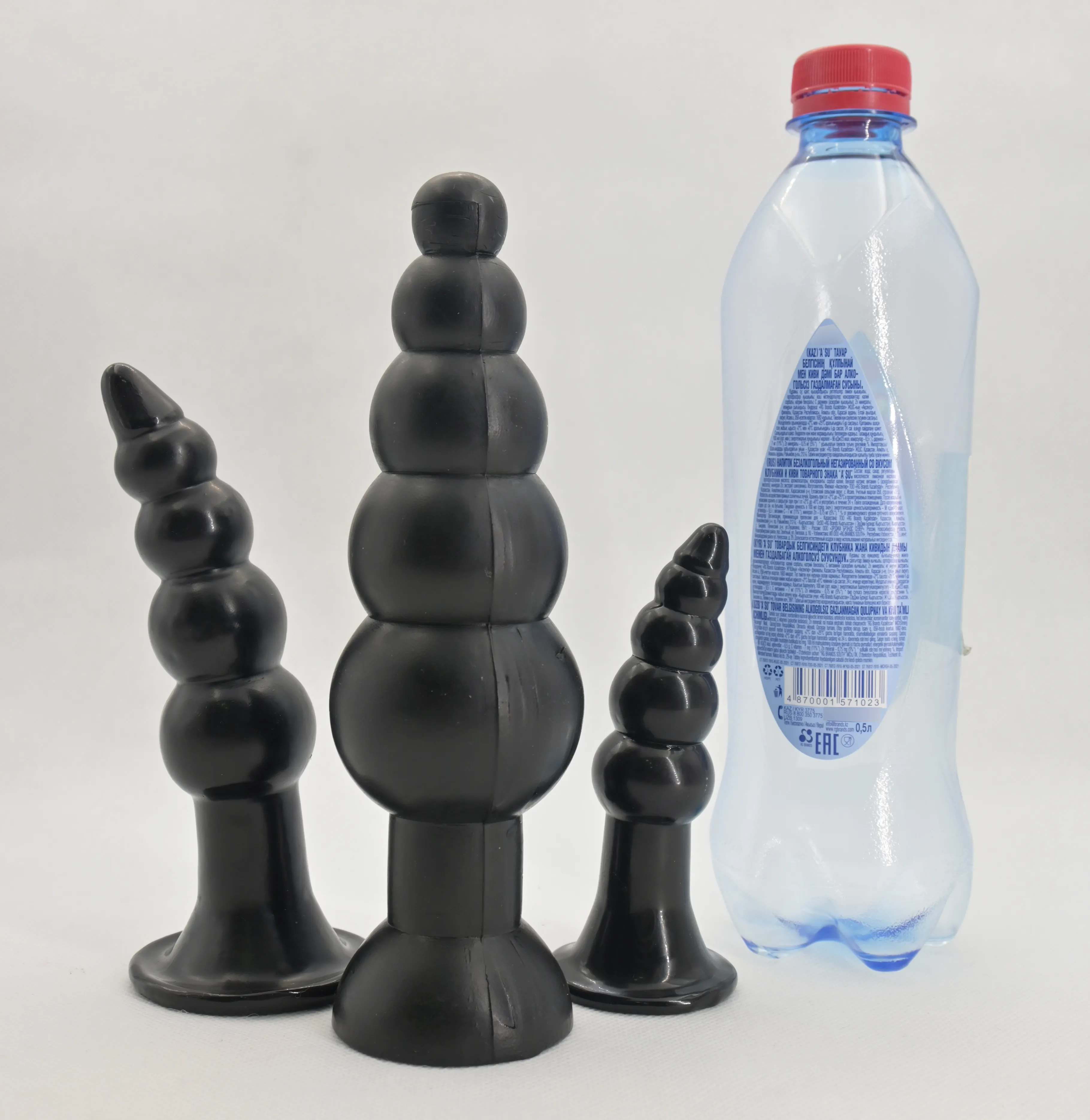 Три анальные втулки-елочки Rubicon рядом с бутылкой воды