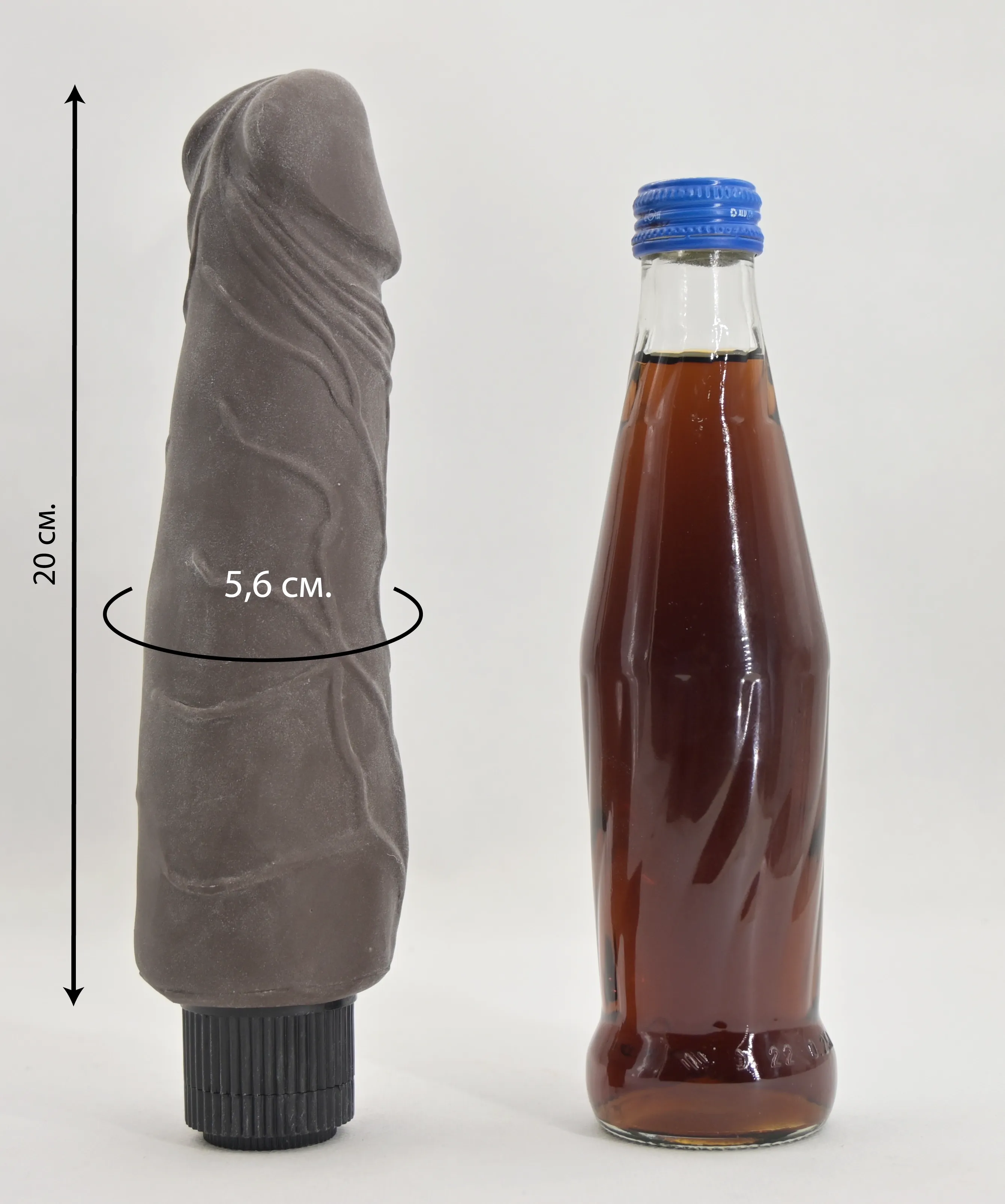Размеры шоколадного вибратора Greedy Guy Brown в сравнении со стеклянной бутылкой 0,33 л.